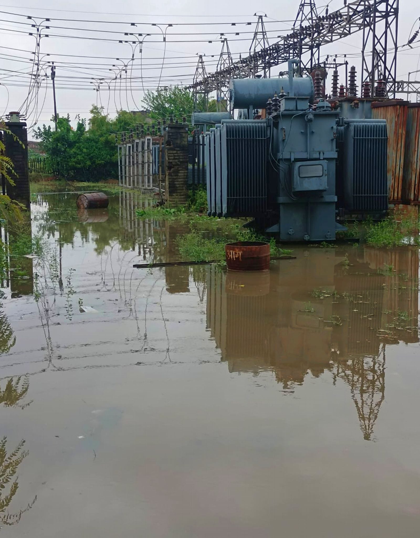 बिल्सी में टूटे पोल को बदलती बिजली विभाग की टीम