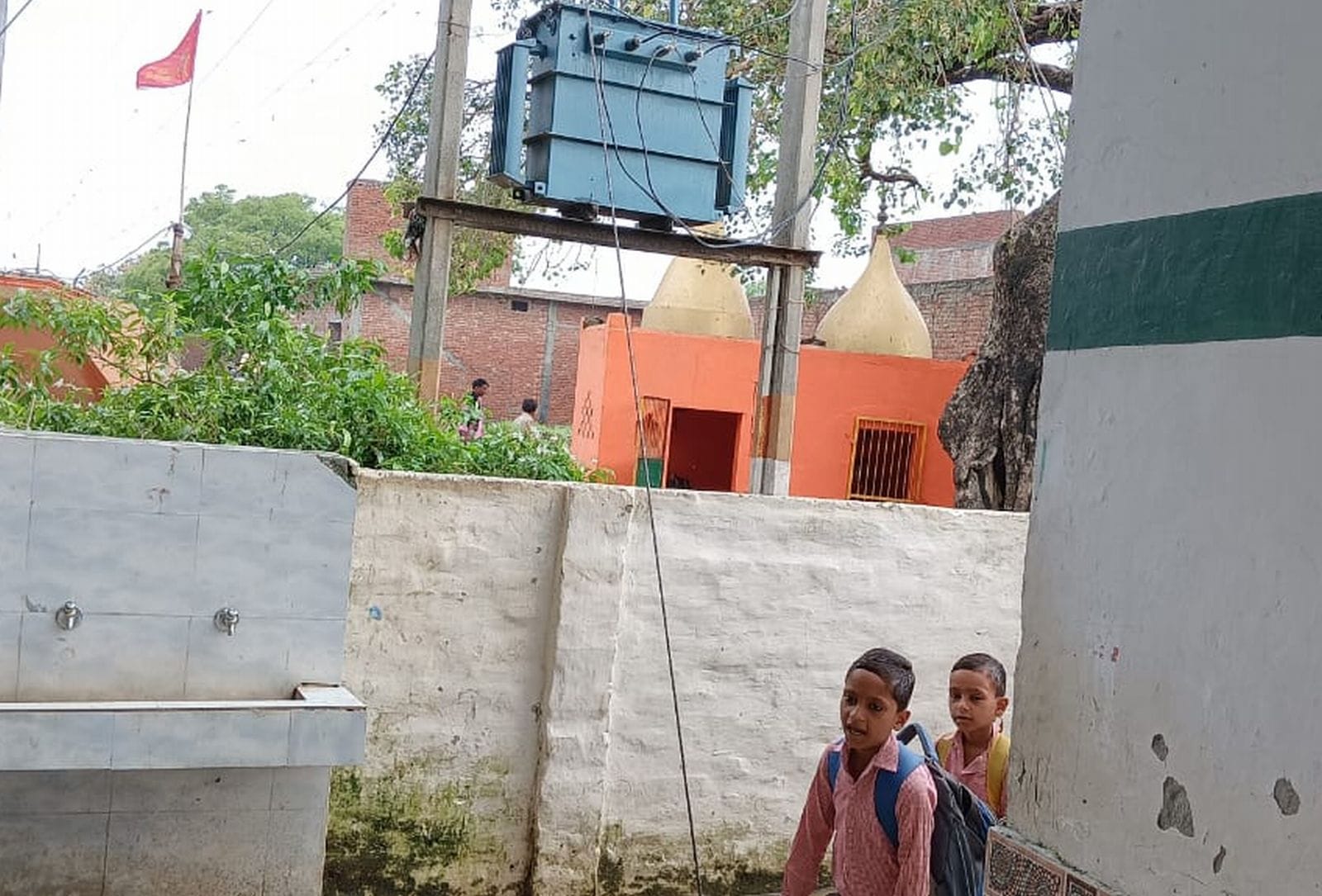 प्राथमिक स्कूल सोई में पानी में लगे तार के बीच गुजरता बालक। संवाद