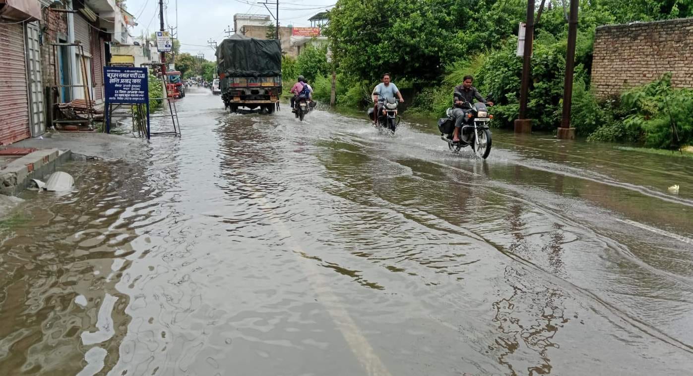 रामपुर में गुरुवार की सुबह बारिश में जौहर रोड पर जल भराव से गुजरती युवतियां।   संवाद