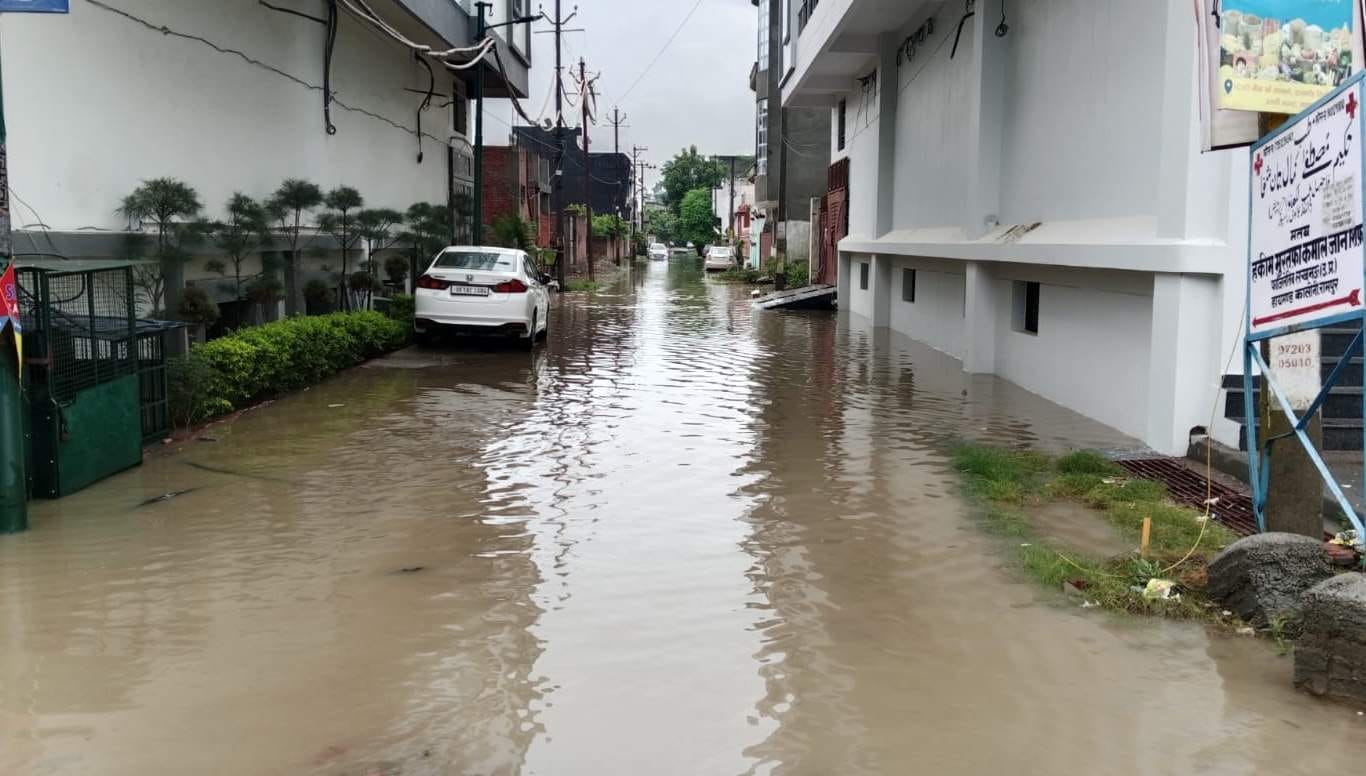 रामपुर में गुरुवार की सुबह बारिश में जौहर रोड पर जल भराव से गुजरती युवतियां।   संवाद