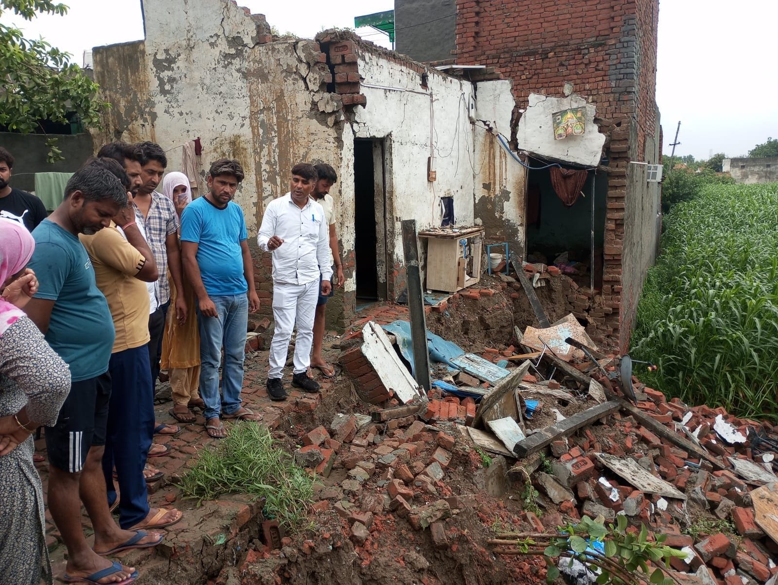 फोटो 20- गांव सांदल कलां में बारिश के दौरान गिरे मकान का जायजा लेने पहुंचे जिला पार्षद संजय बड़
