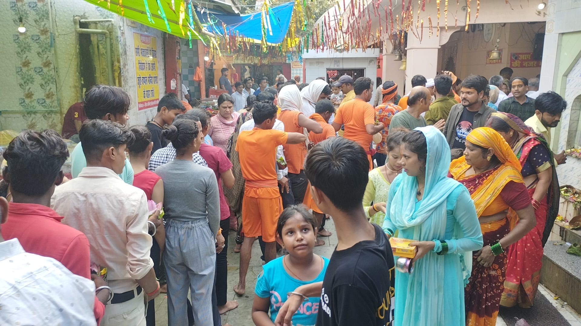 शिव मंदिर गर्भ ग्रह के बाहर लगी भक्तों की कतार के पास खड़ा नंदी