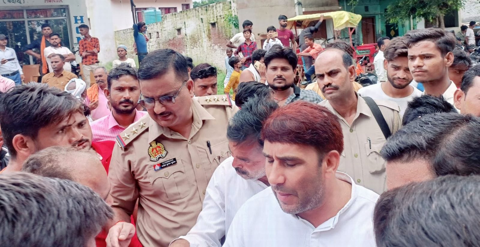 बिसौली में सड़क पर रास्ता रोककर बैठे कांवड़िये।