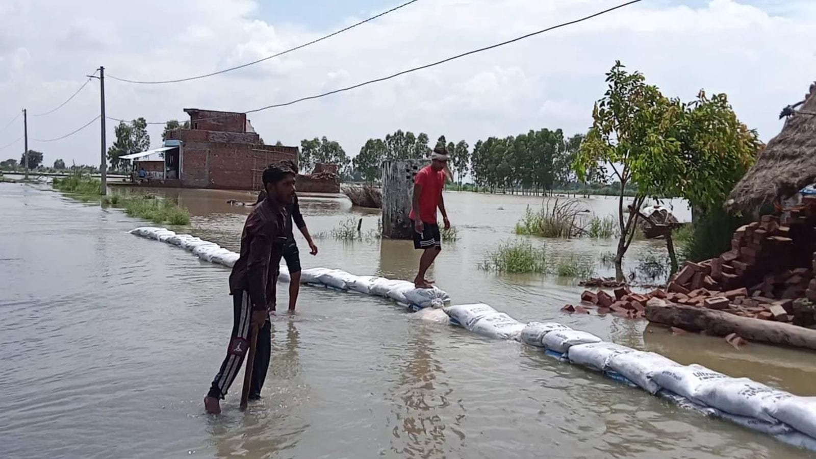 उसहैत के जटा गांव में खाट पर बैठे महिला व बच्चे