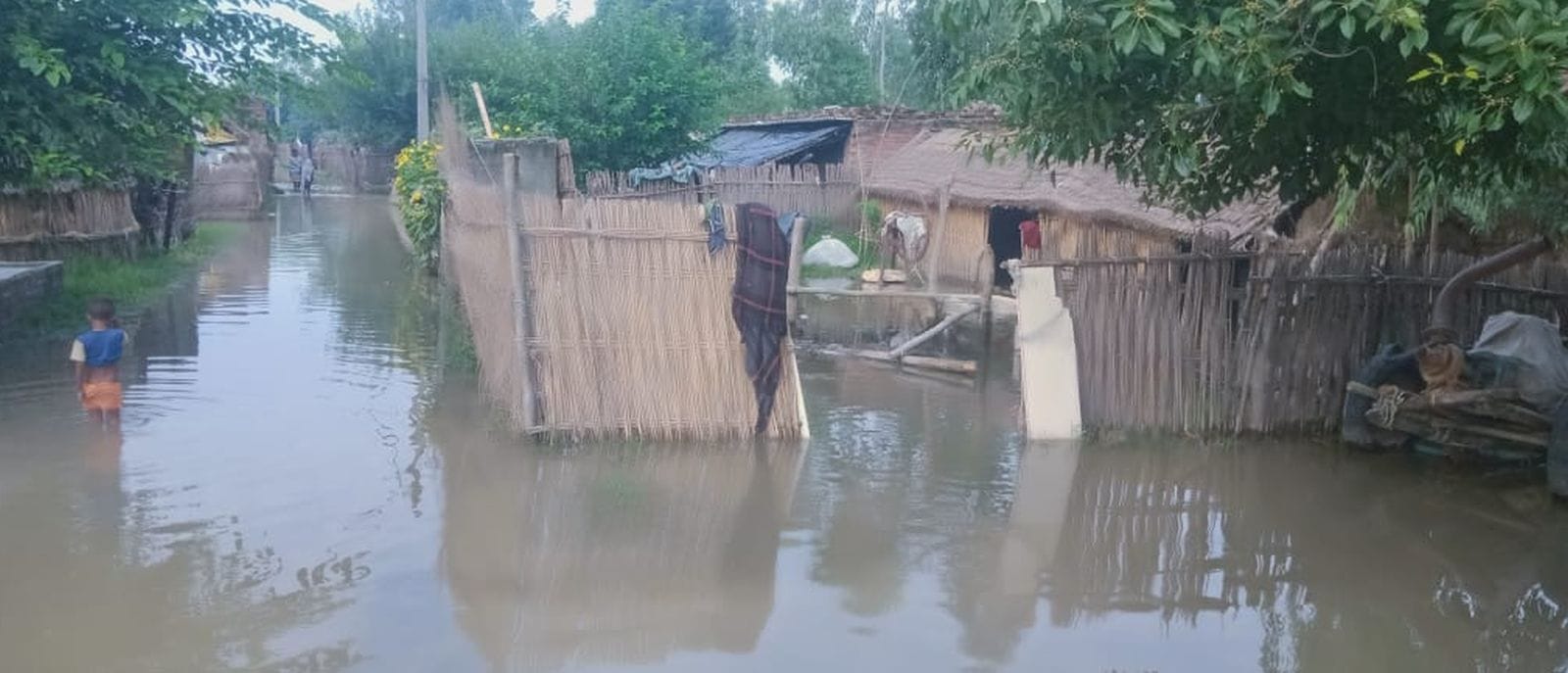 उसहैत के जटा गांव में खाट पर बैठे महिला व बच्चे