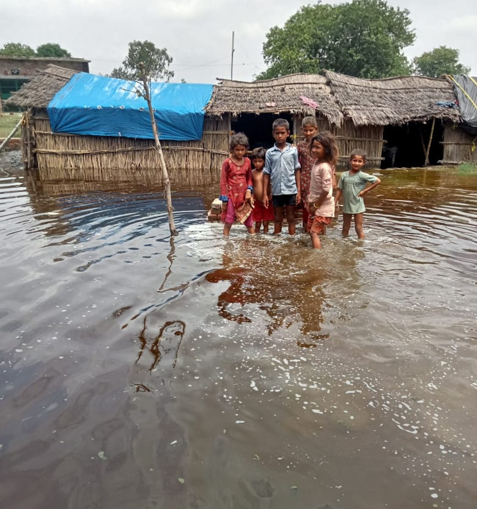 उसहैत के जटा गांव में खाट पर बैठे महिला व बच्चे