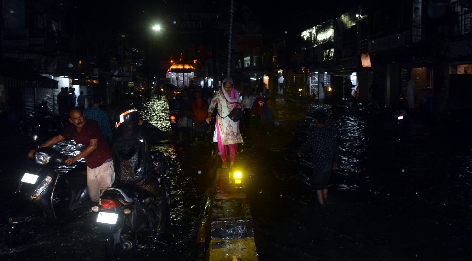 शहर में मूसलाधार बारिश से रुडकी रोड पर जलभराव से गुजरता टैक्टर।