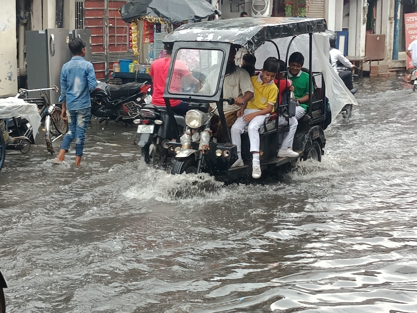 शहर में सोमवार की दोपहर हुई बारिश में छाता लगाकर जाता युवक । संवाद