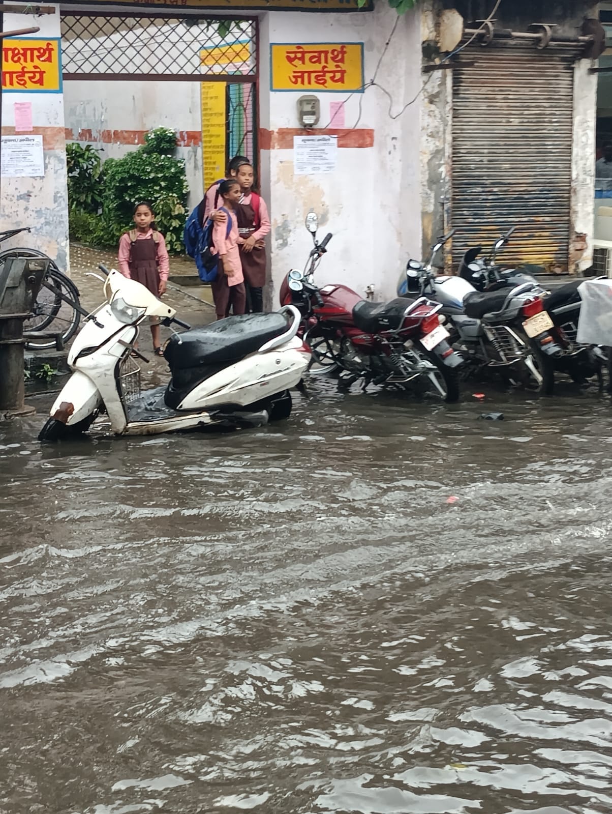 शहर में सोमवार की दोपहर हुई बारिश में छाता लगाकर जाता युवक । संवाद
