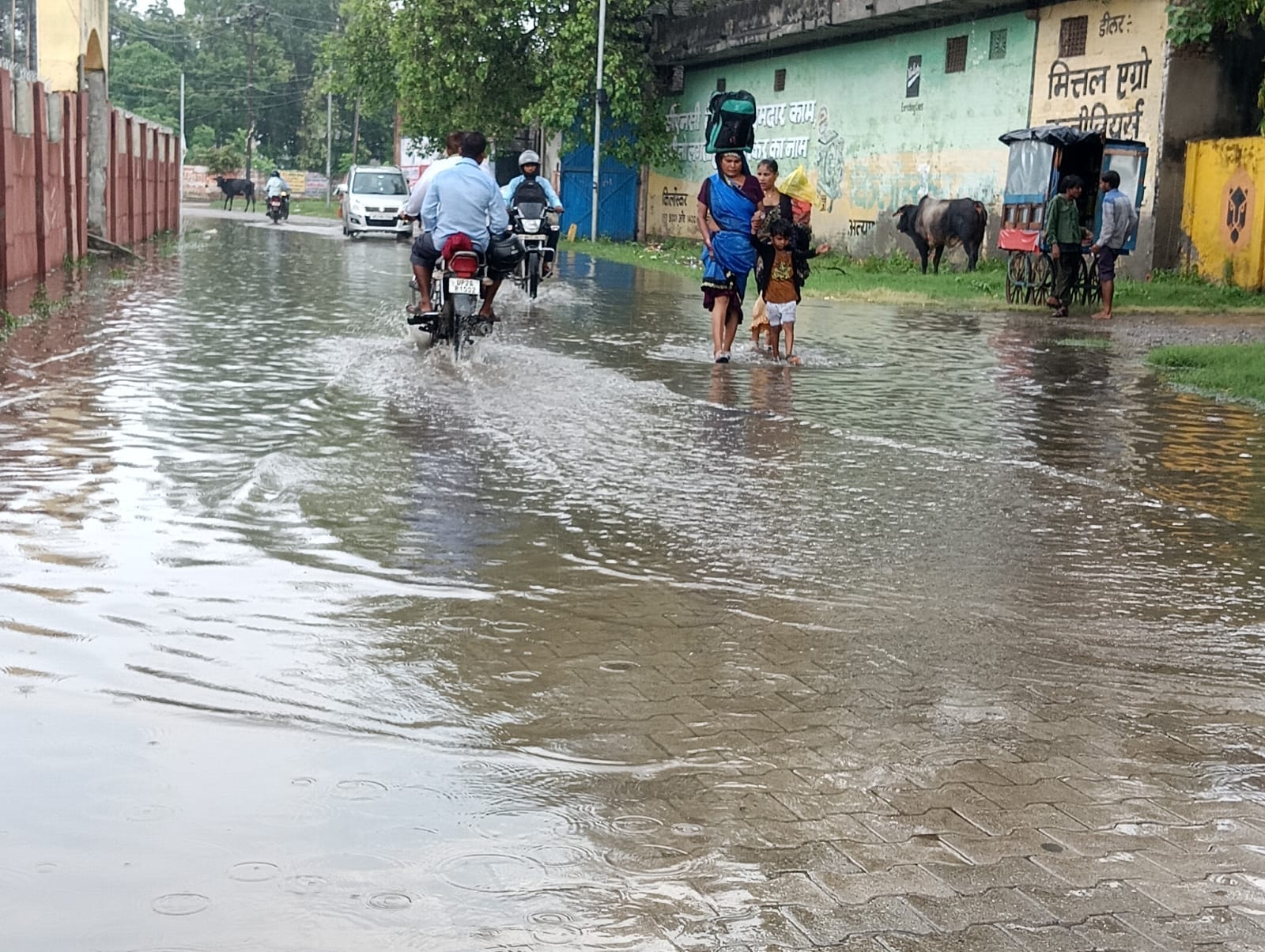 शहर में सोमवार की दोपहर हुई बारिश में छाता लगाकर जाता युवक । संवाद