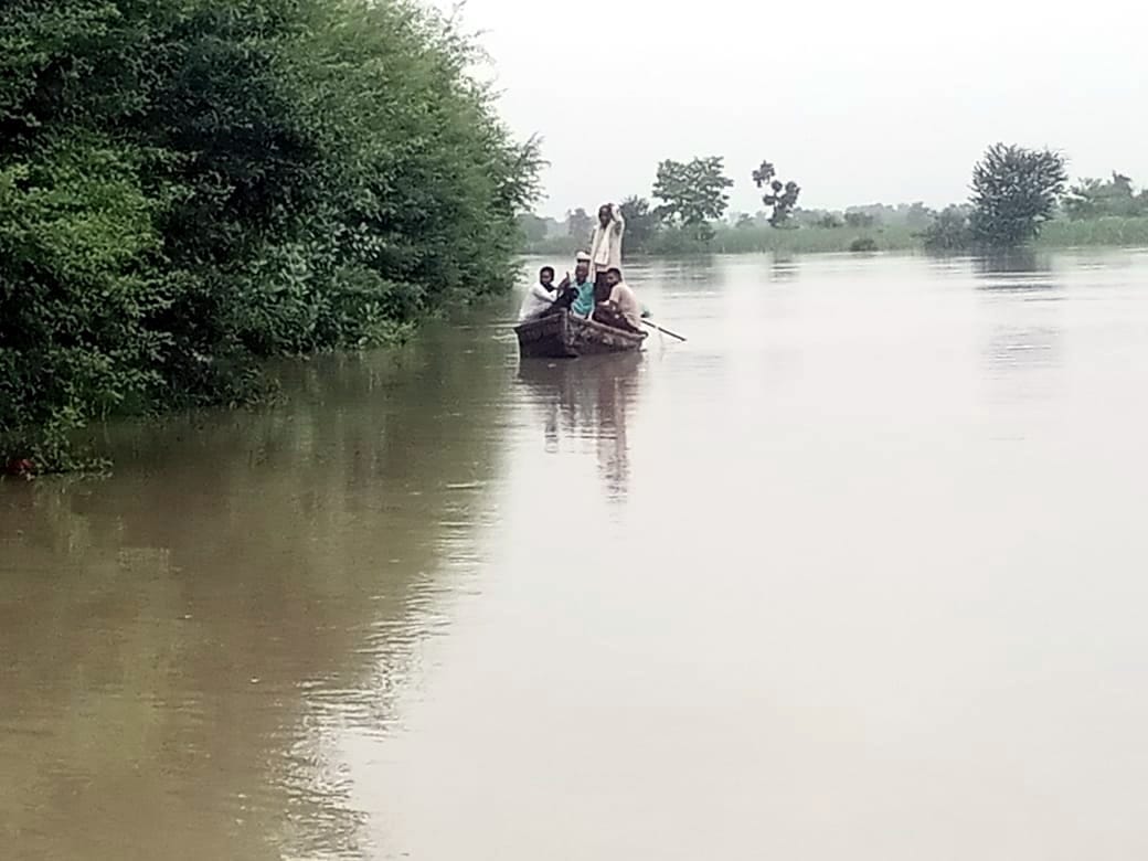 खाम्भी से श्रीनगर  तटबंध पर नाव से  जाते हुए बाढ़ पीड़ित