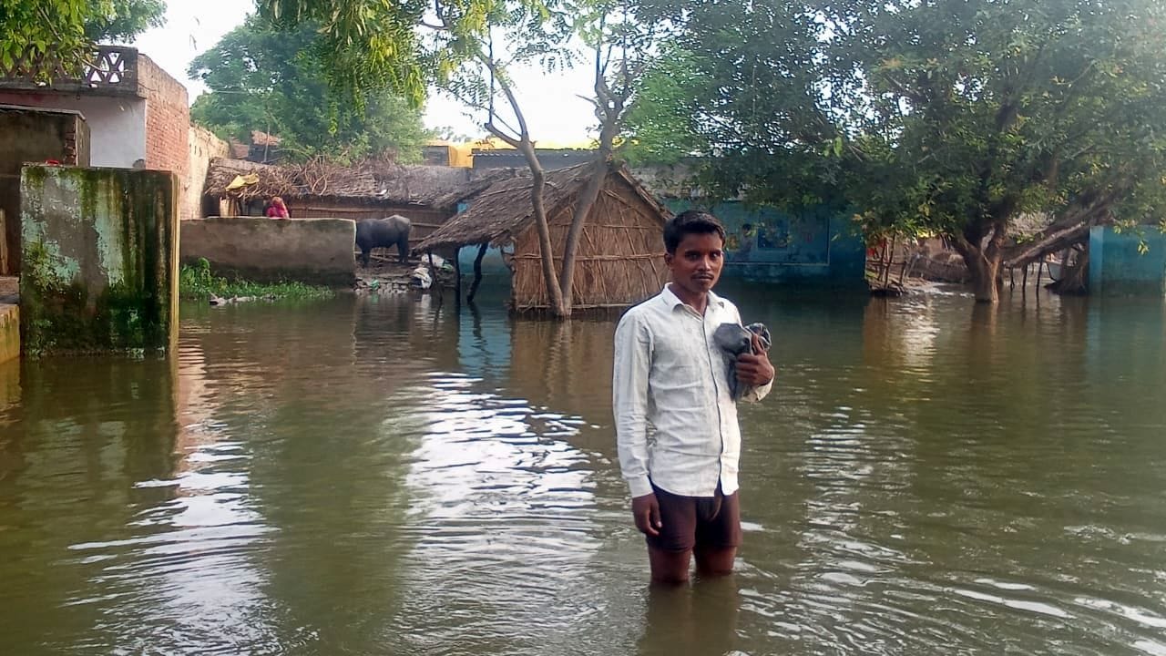 मिर्जापुर के मस्जिद नगला में बाढ़ से घिरे एक घर से निकलता छोटा बच्चा। संवाद