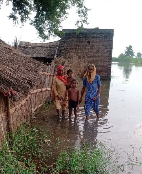 मिर्जापुर के मस्जिद नगला में झोपड़ी के सामने खाना बनाता परिवार। बाढ़ पीड़ित