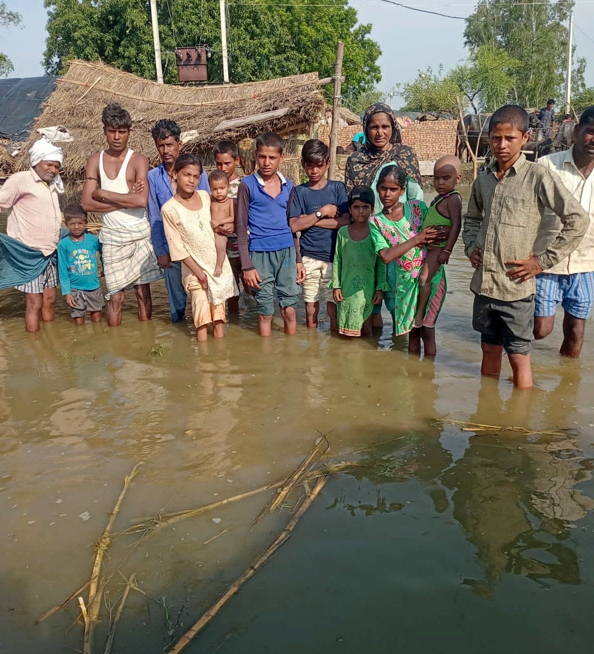 मिर्जापुर के मस्जिद नगला में झोपड़ी के सामने खाना बनाता परिवार। बाढ़ पीड़ित