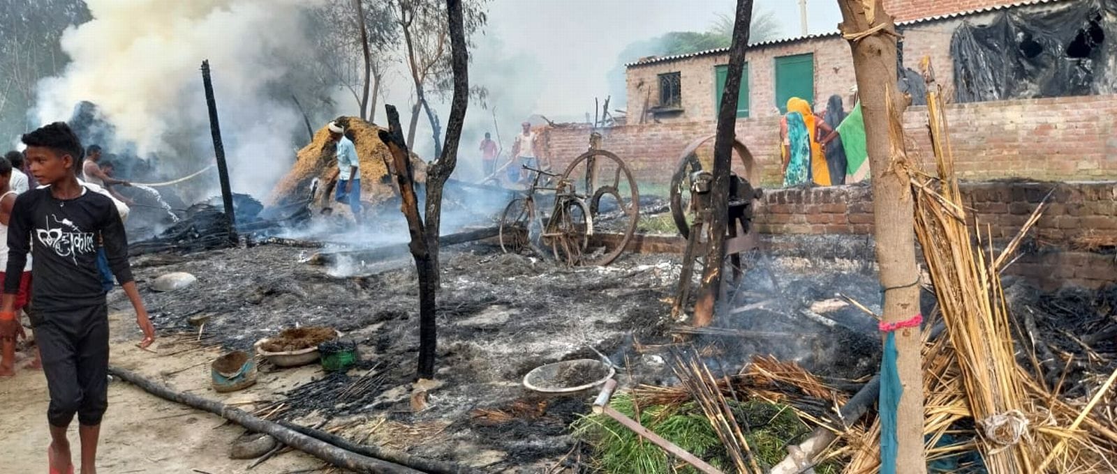 कादरचौक के गांव मोहन नगला में भूसे के ढेर में लगी आग बुझाते लोग। संवाद