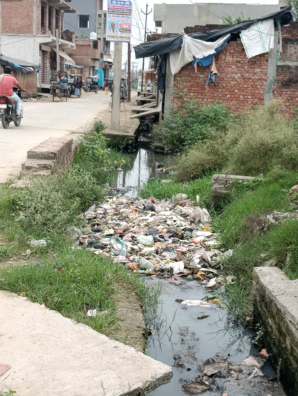 शहर में ओवरब्रिज के पास सड़क किनारे लगे नल के पास फैंली पडी गंदगी । संवाद