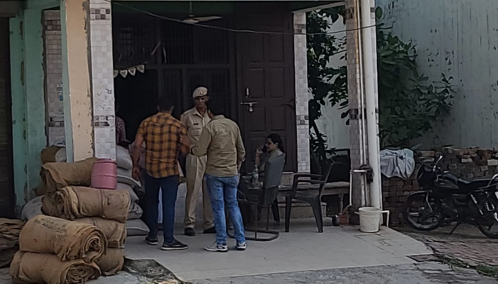फोटो :34: गोहाना में आढ़ती की दुकान के बाहर बैठा पुलिसकर्मी व अन्य। संवाद