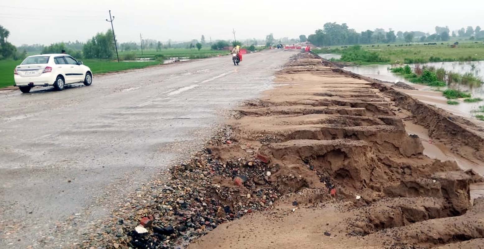 गांव रामपुर कलां में घरों में पानी भर जाने से घरेलू सामान ले जाता युवक