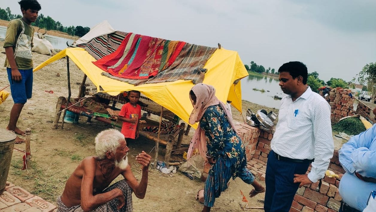 मिर्जापुर के जलमग्न ग्राम पैलानी में चारपाई पर भूसा ले जाते युवक। संवाद
