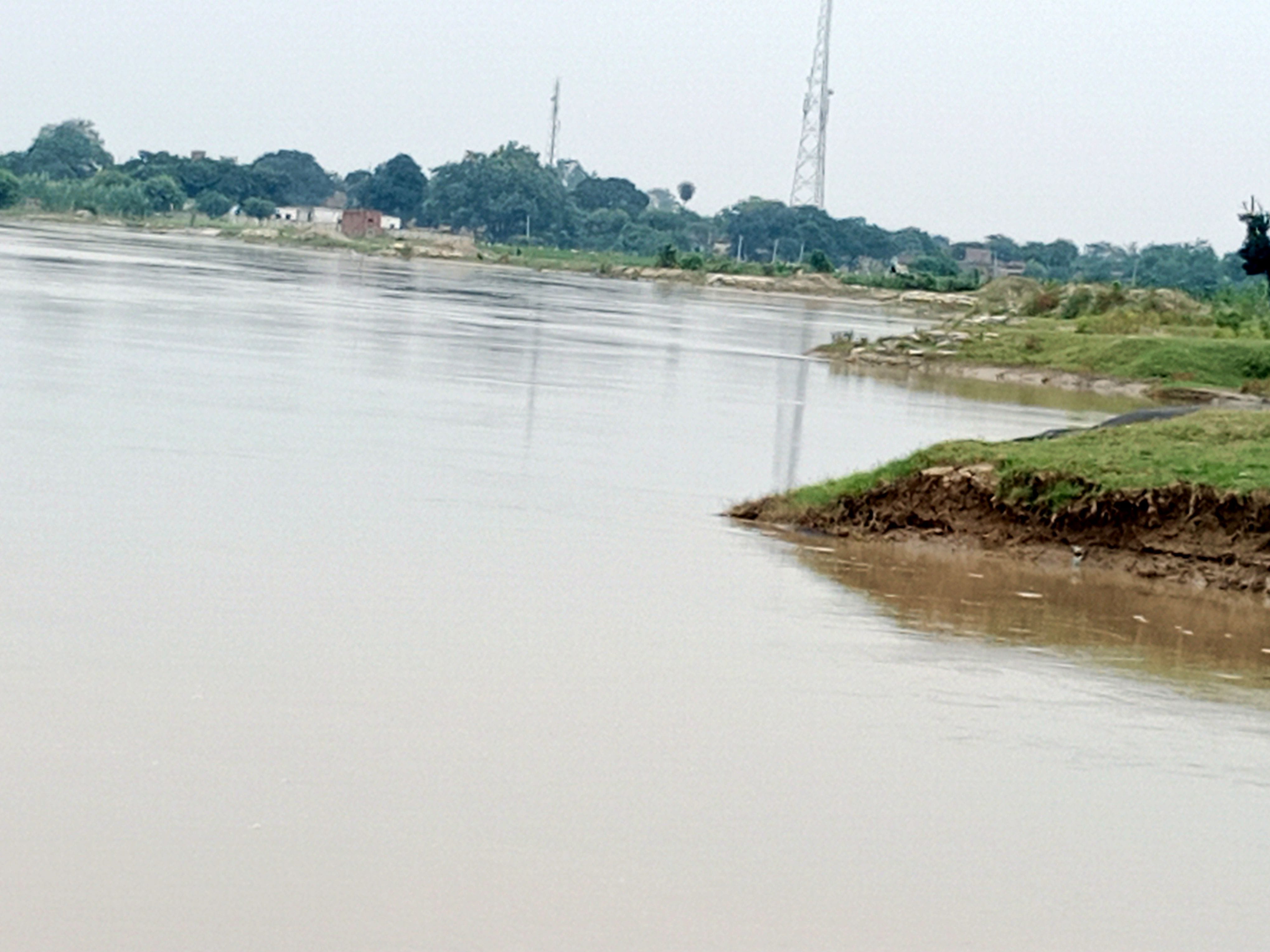 मिर्जापुर के जलमग्न ग्राम पैलानी में चारपाई पर भूसा ले जाते युवक। संवाद