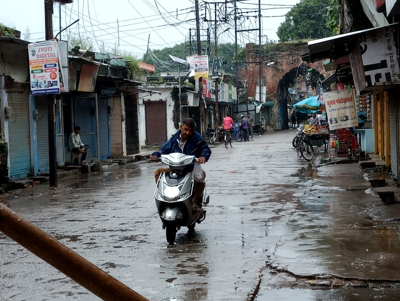 बारिश में छाता लगाकर जाती स्कूली छात्राएं । संवाद