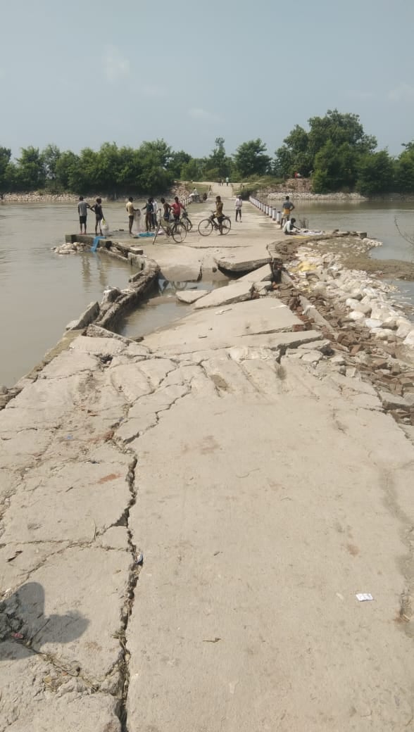 पलिया के मझौरा से इमलिया जाने वाले पर पानी कम होने के बाद गुजरते वाहन व खड़ी नाव। पलिया के मझौरा से इमलिया जाने वाले पर पानी कम होने के बाद गुजरते वाहन व खड़ी नाव।