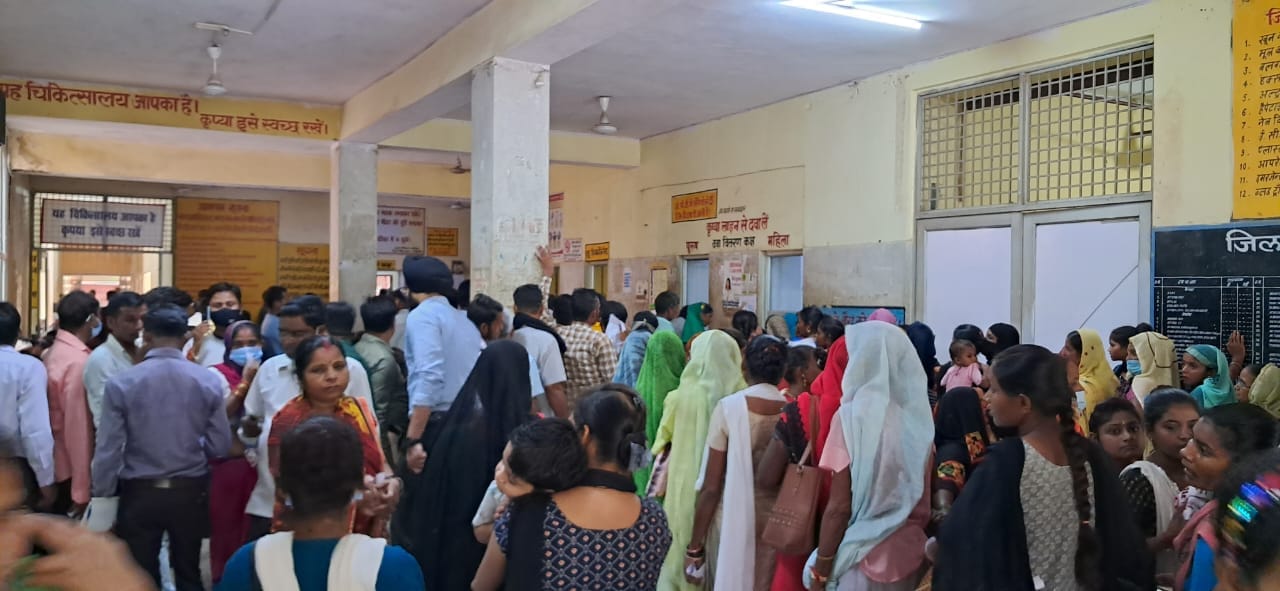 जिला चिकित्सालय में चिकित्सक कक्ष के बाहर तक लगी लाइन में नीचे बैठे लोग । संवाद जिला चिकित्सालय में चिकित्सक कक्ष के बाहर तक लगी लाइन में नीचे बैठे लोग । संवाद