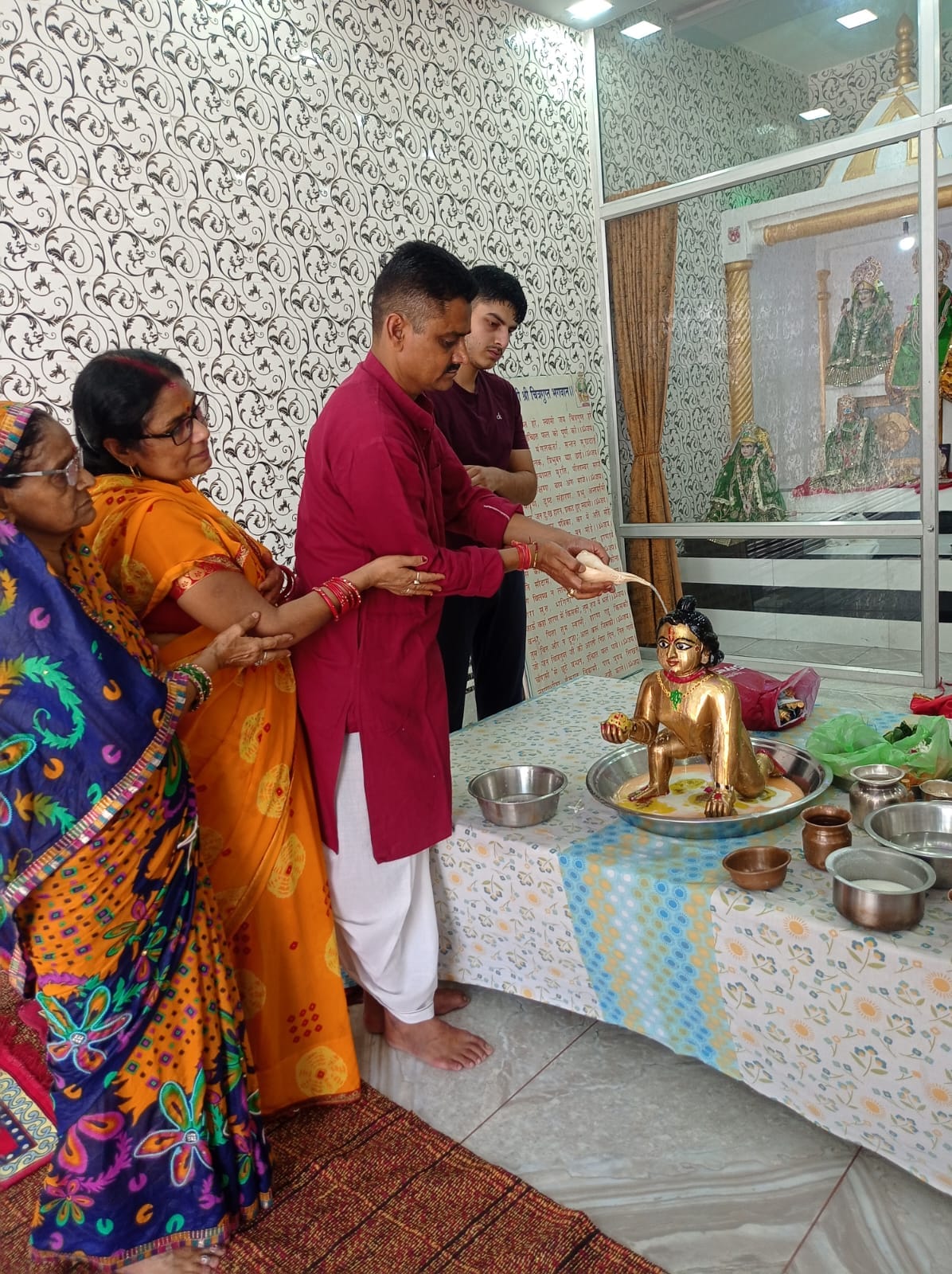 शहर के मोहल्ला साहुकारा स्थित श्री राधा रमण मंदिर में श्रीकृष्ण का अभिषेक करते सुधीर चंद्र गो