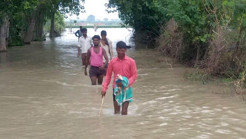 गांव एलमनगर की बस्ती तक पहुंचे बाढ़ का पानी से निकलते लोग।संवाद