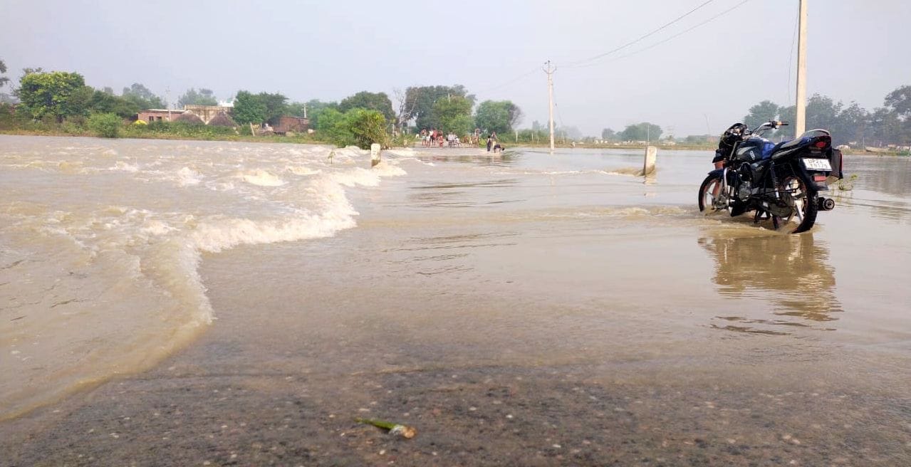 गांव एलमनगर की बस्ती तक पहुंचे बाढ़ का पानी से निकलते लोग।संवाद