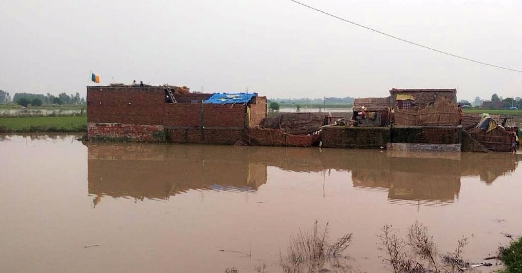 गांव एलमनगर की बस्ती तक पहुंचे बाढ़ का पानी से निकलते लोग।संवाद