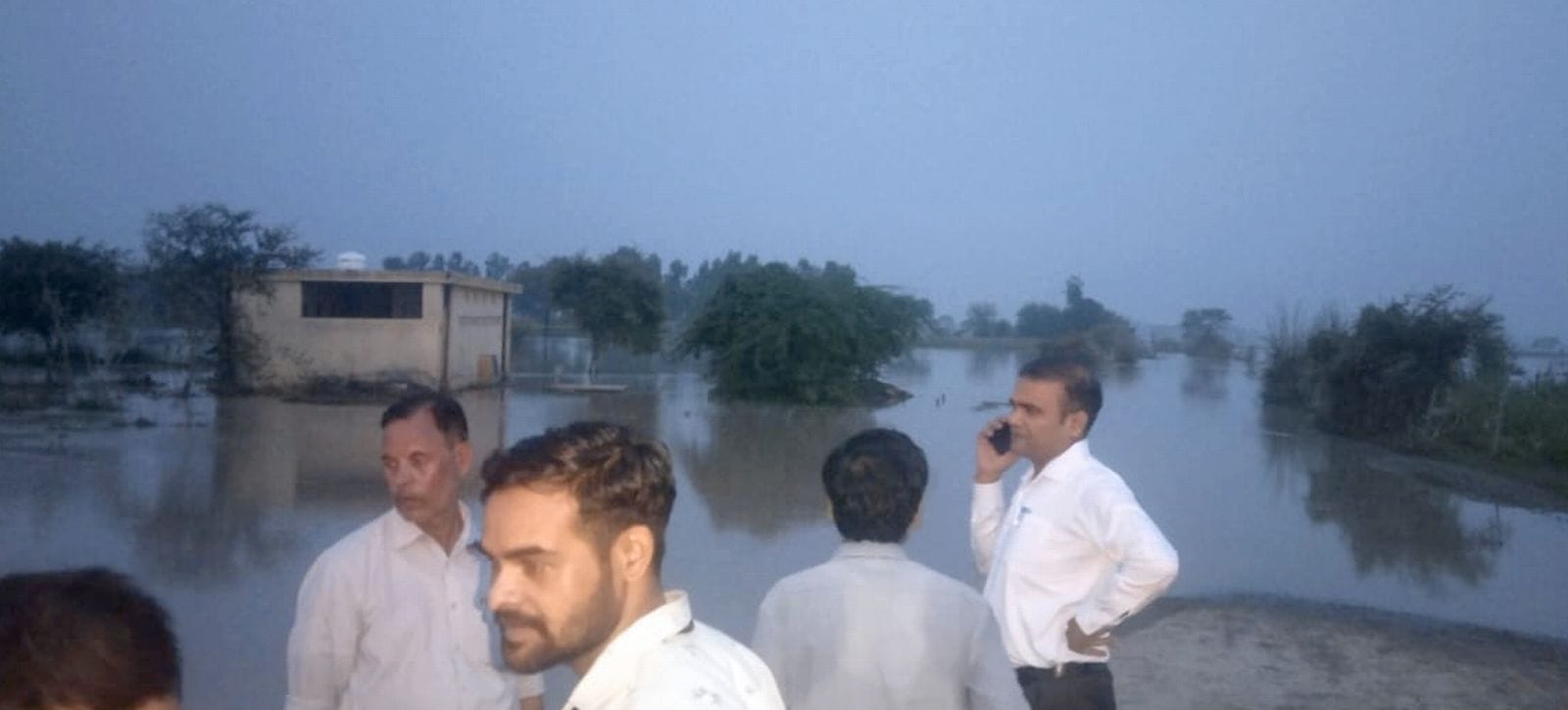 हजरतपुर से लालपुर खादर के बीच सड़क पर भरे पानी में चलती नांव। संवाद