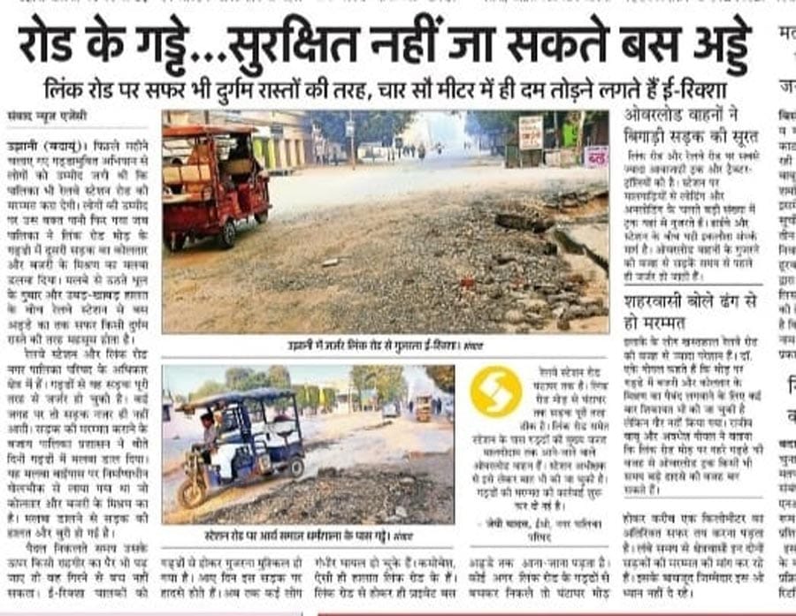 उझानी में स्टेशन रोड के गड्ढे भरने को पत्थर मिश्रित बजरी अनलोड करता ट्रक। संवाद