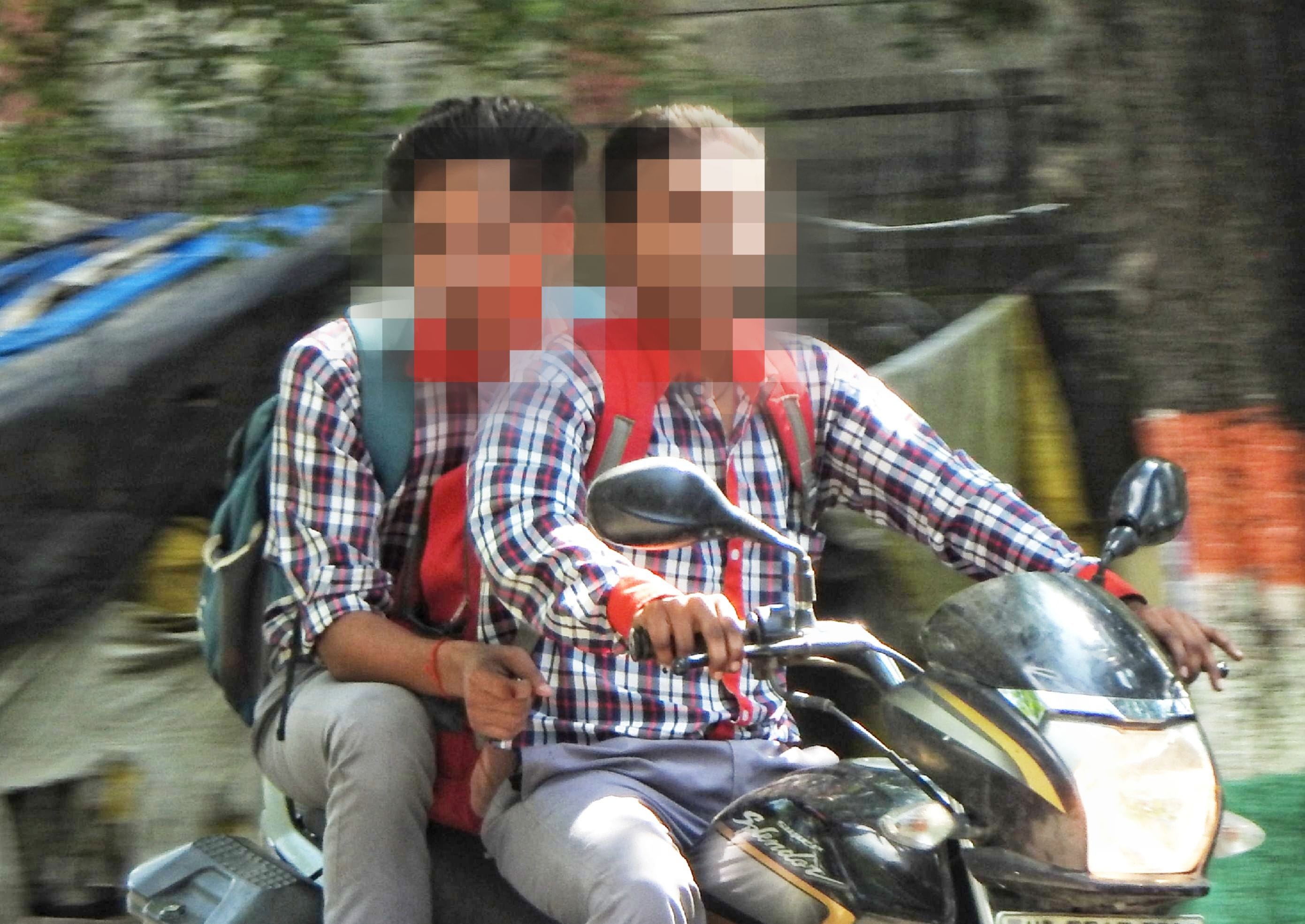शहर के सिद्धार्थ तिराहे पर बाइक पर बिना हेलमेट के जाते तीन छात्र। संवाद