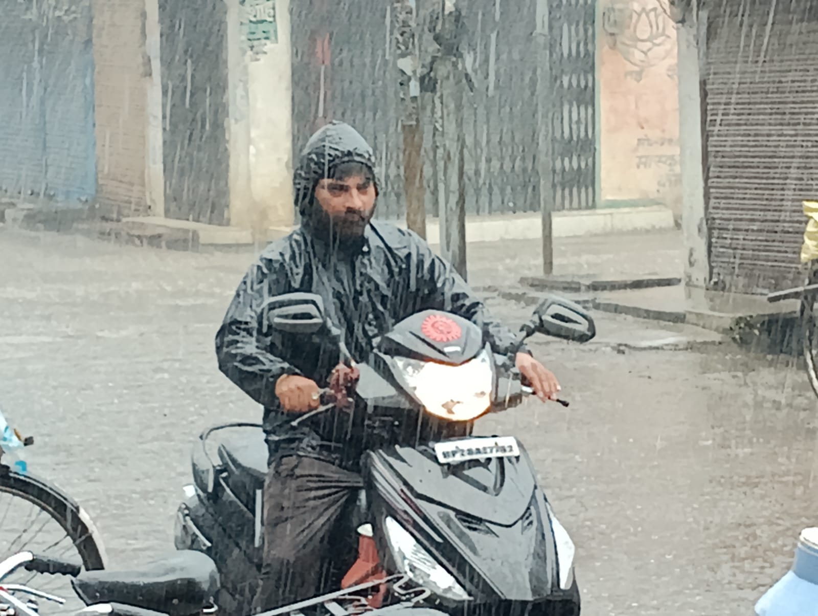 शहर में रविवार की सुबह हुई तेज बारिश में छाता लगाकर जाते बच्चे । संवाद