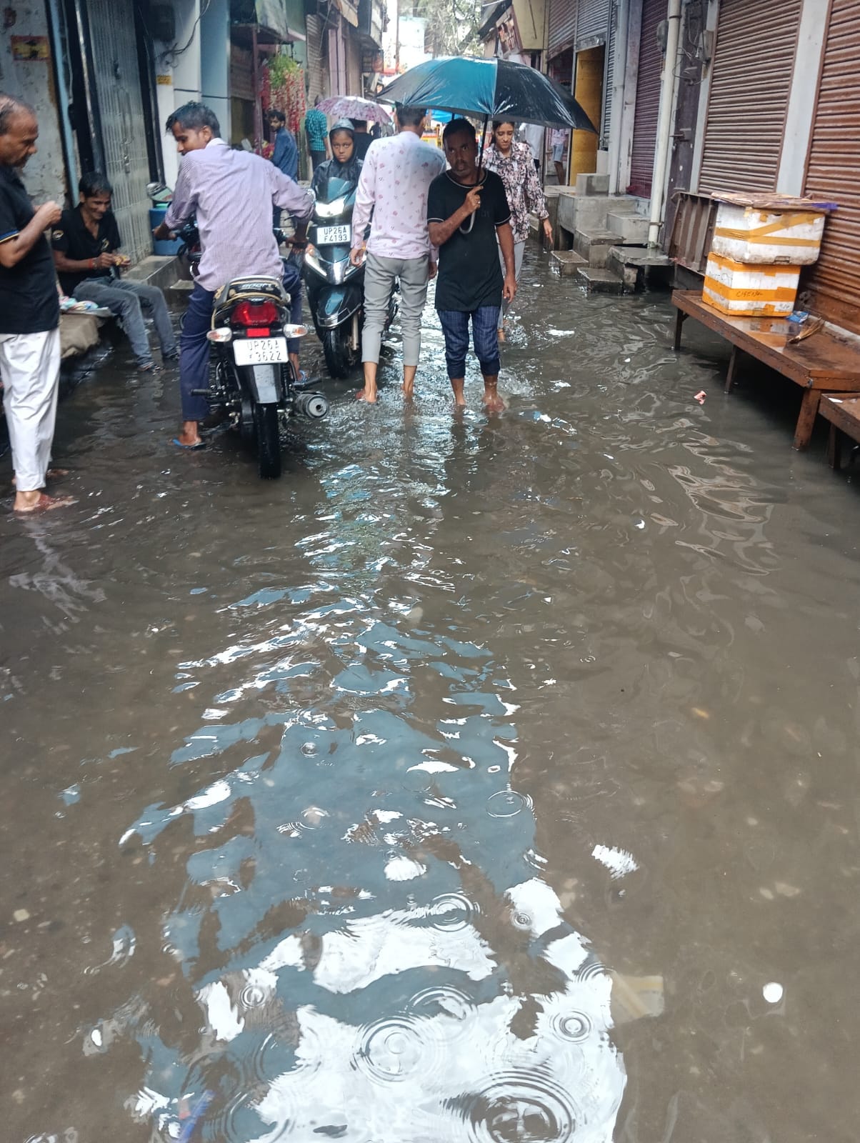 शहर में रविवार की सुबह हुई तेज बारिश में छाता लगाकर जाते बच्चे । संवाद