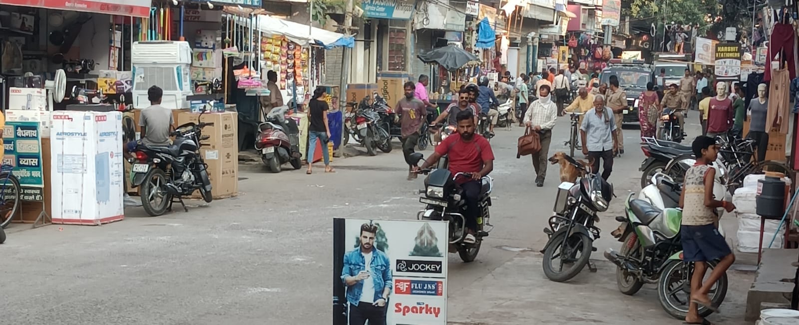 शहर की गांधी स्टेडियम रोड पर सड़क  किनारे खड़े वाहन । संवाद