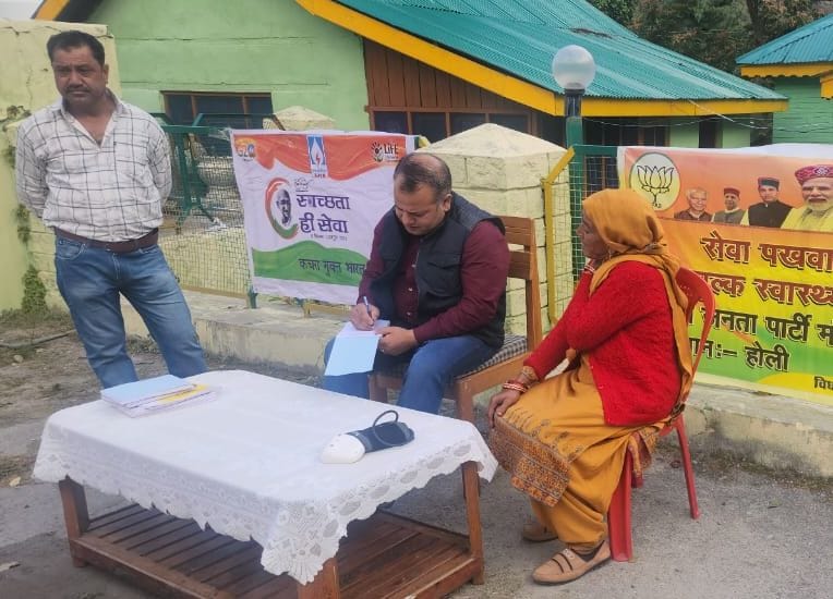 होली में आयोजित चिकित्सा जांच शिविर के दौरान स्वास्थ्य जांच करवाने के लिए लाइनों में खड़े लोग। 