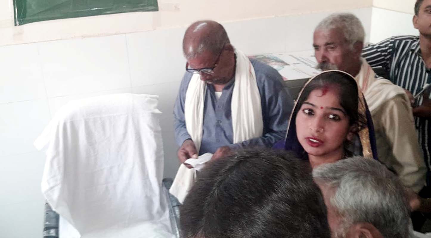 खुटार सीएचसी पर डॉक्टर नहीं होने पर थक हार कर जमीन पर बैठे रोगी। संवाद