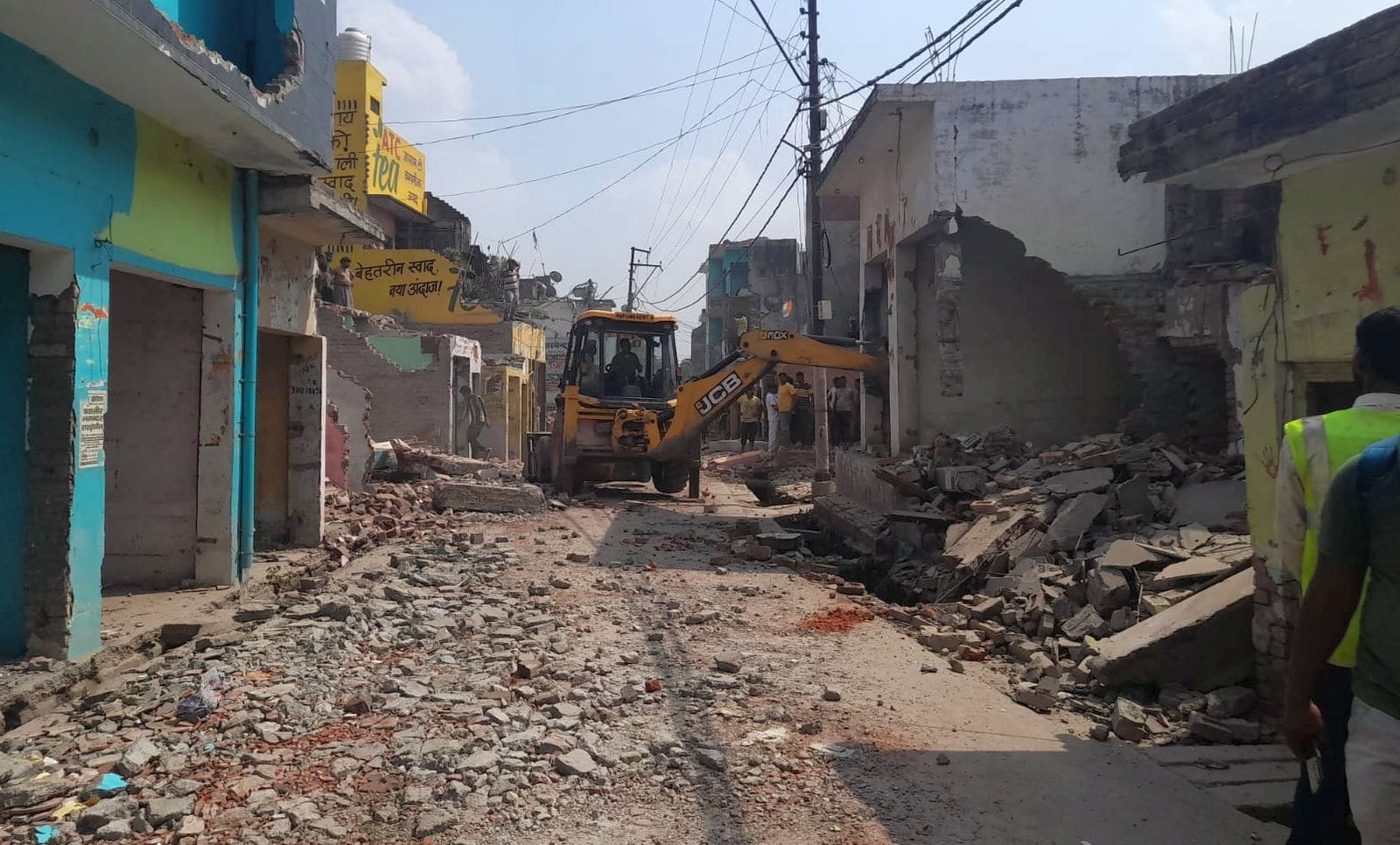 दातागंज में मंदिर की बाहरी दीवार को तोड़ते कर्मचारी। संवाद