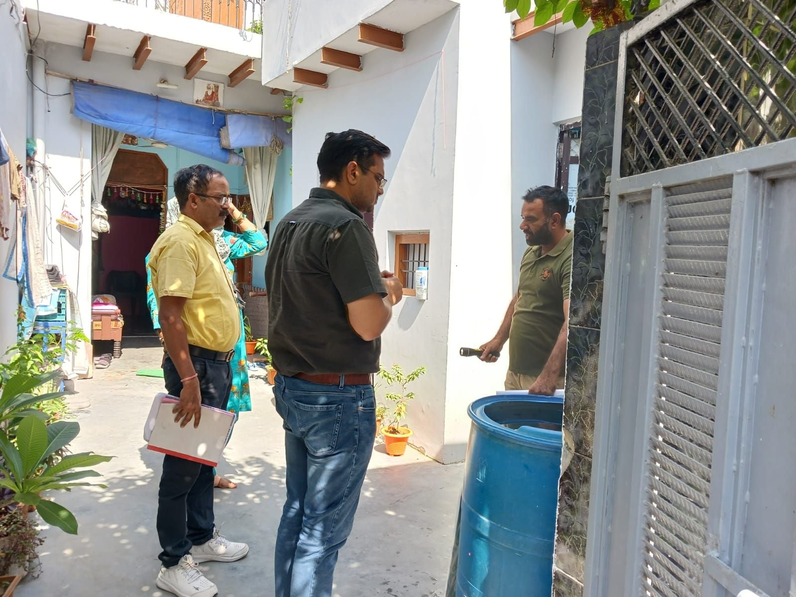 फोटो 28. डोर-टू-डोर सर्वे के दौरान ड्रम में भरे पानी में लार्वा चेक करते जिला मलेरिया अधिकारी ड