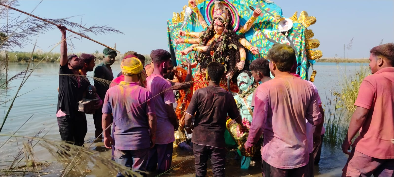 न्यूरिया बंगाली कॉलोनी की खकरा नदी में मूर्ति विसर्जन करते श्रद्धालु । संवाद