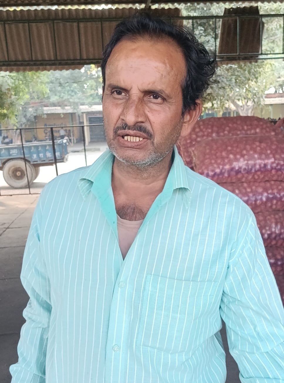 मंडी में प्याज की छटाई करती महिला । संवाद
