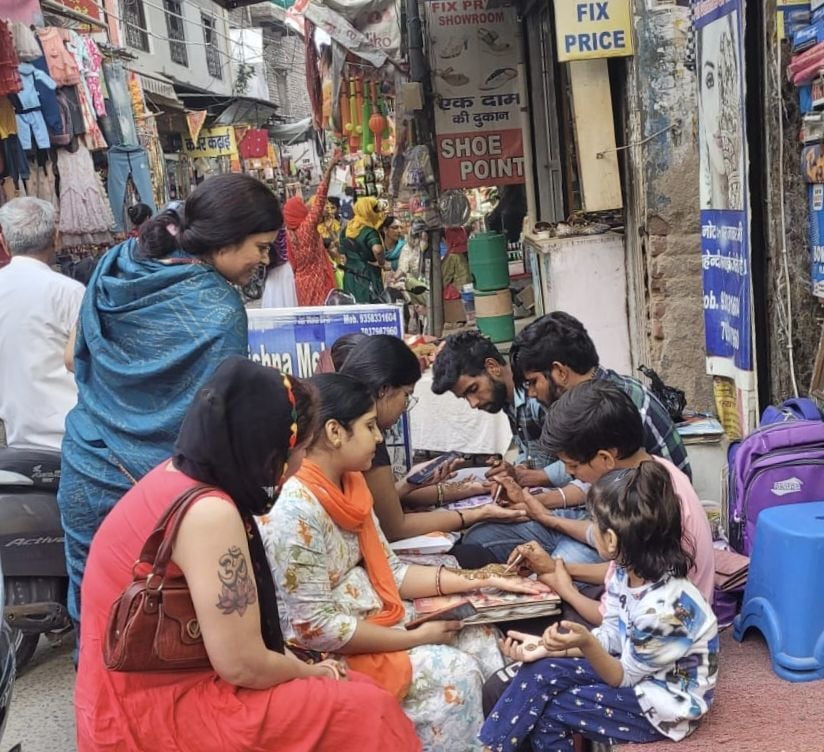 करवा चौथ को लेकर नारनौल के बाजार में मेहंदी लगवातीं महिलाएं। करवा चौथ को लेकर नारनौल के बाजार में मेहंदी लगवातीं महिलाएं।