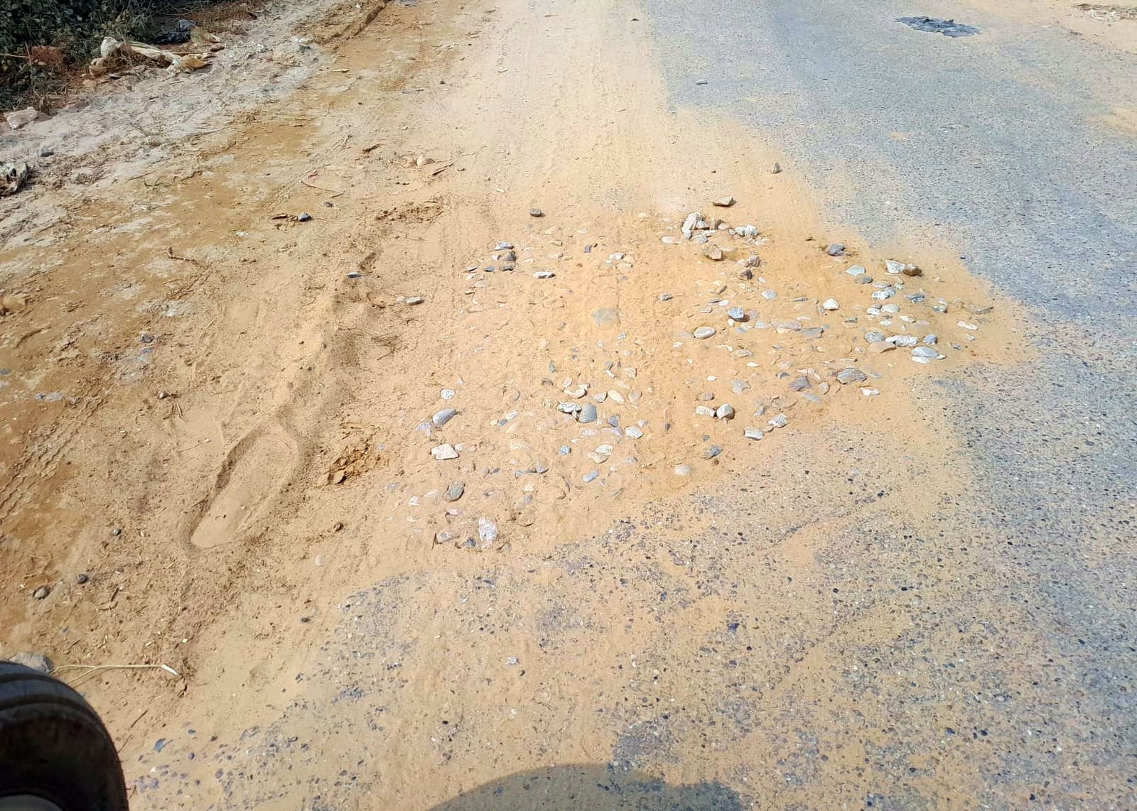 कुरऊ रोड पर गड्ढो में डाली जा रही मिट्टी। संवाद कुरऊ रोड पर गड्ढो में डाली जा रही मिट्टी। संवाद