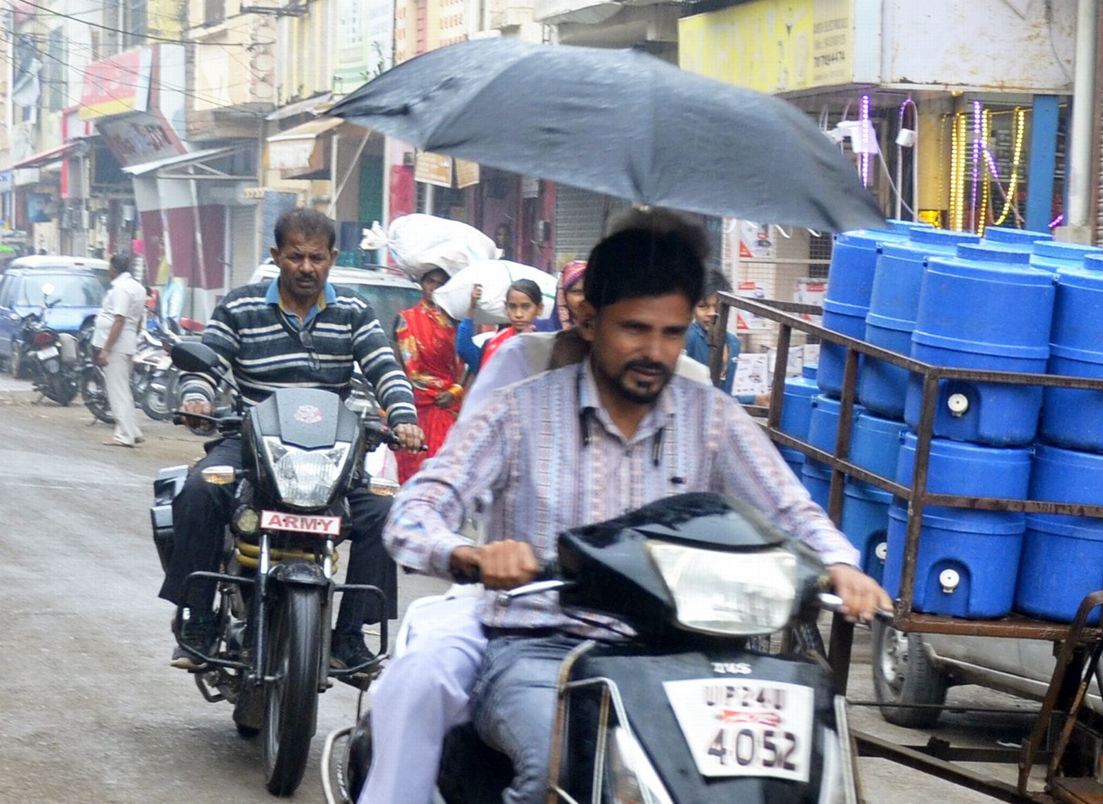 बारिश में बच्चे को कपड़े से ढक्कर जाती महिला। संवाद बारिश में बच्चे को कपड़े से ढक्कर जाती महिला। संवाद