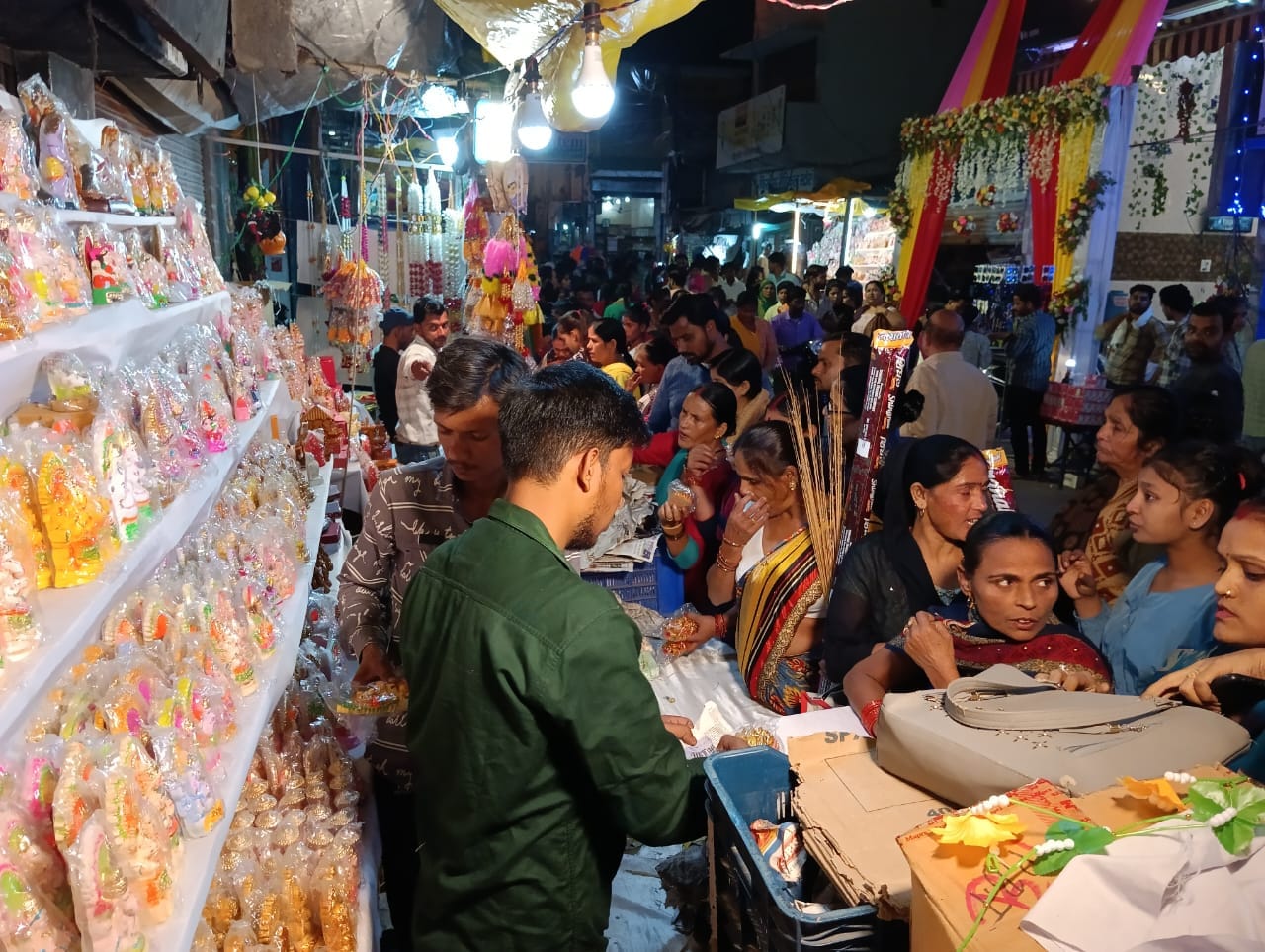 शहर में दीपावली पर्व के लिए सजी एक गेंदे के फूल की दुकान पर फूल खरीदते लोग ।संवाद