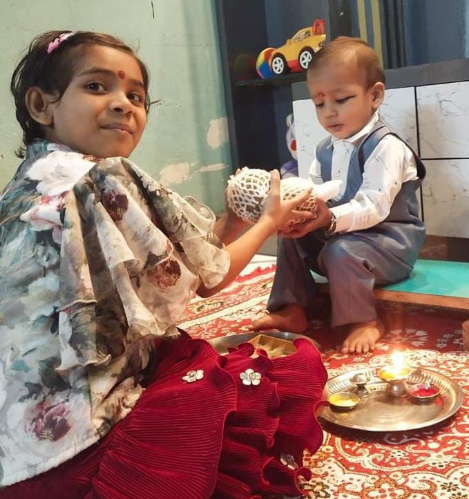 शहर में भाई दूज पर्व पर भाई का टीका करती बहन । संवाद