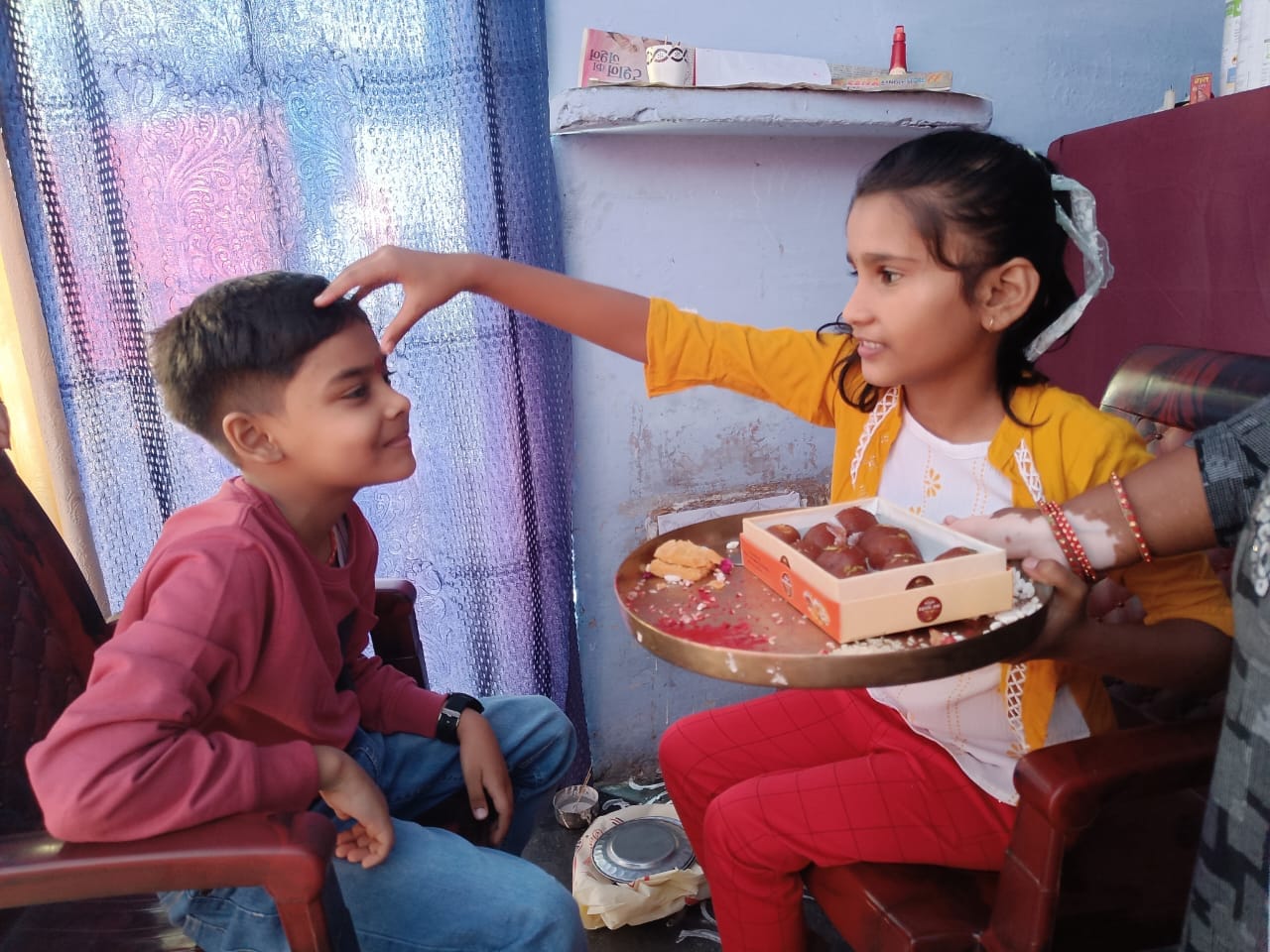 शहर में भाई दूज पर्व पर भाई का टीका करती बहन । संवाद