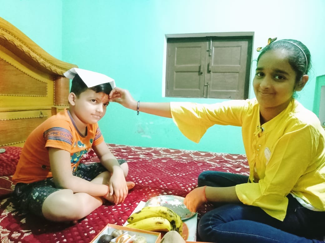 शहर में भाई दूज पर्व पर भाई का टीका करती बहन । संवाद
